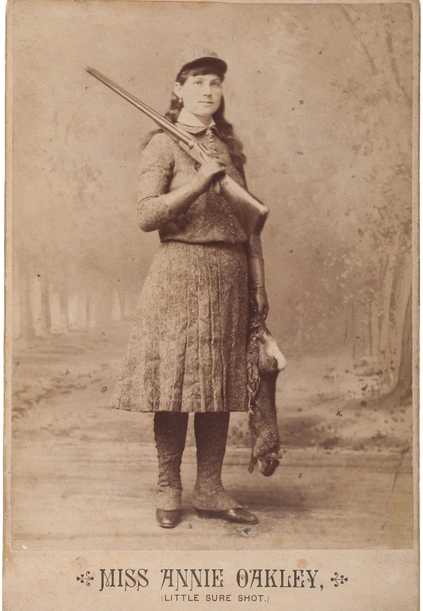 Annie Oakley with a shotgun and a rabbit