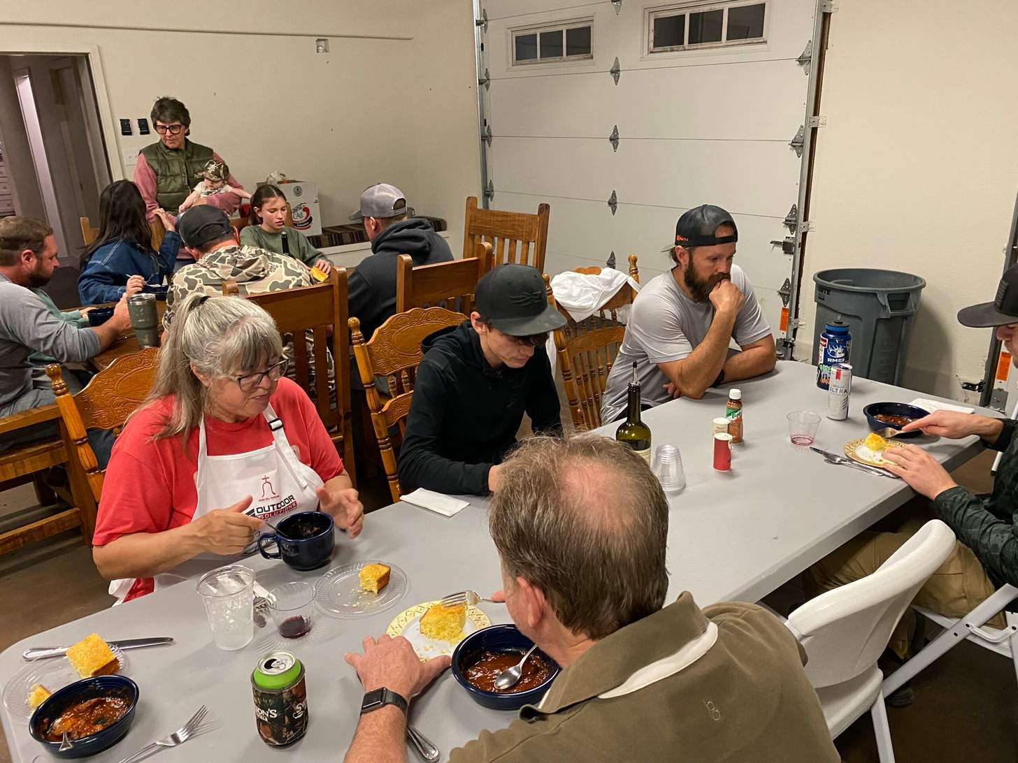 People sit at tables eating game meat at Outdoor Solutions Field to Table event in Oklahoma.