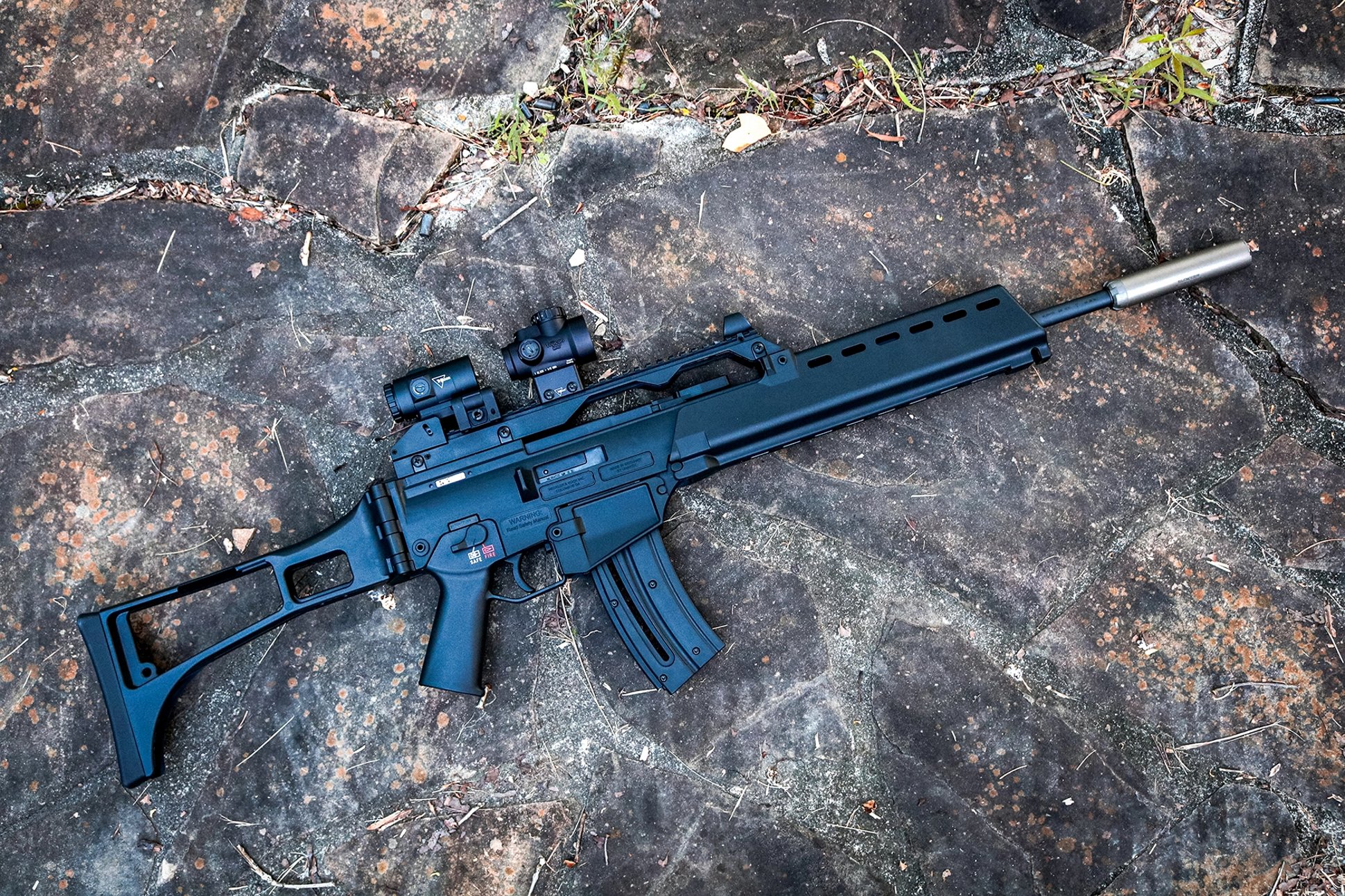 HK G36 Rimfire topped with a Trijicon red dot and magnifier and outfitted with a suppressor