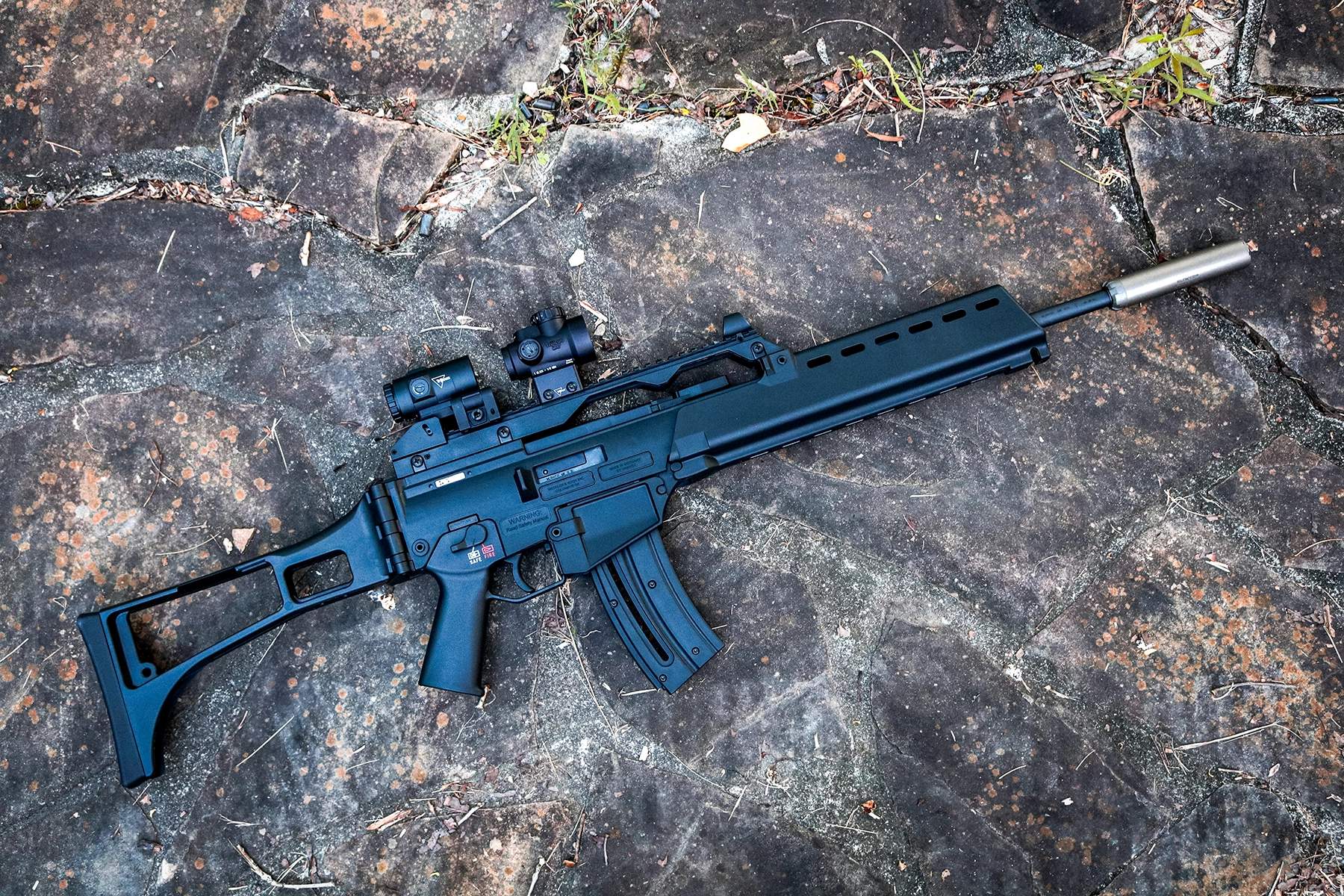 HK G36 Rimfire topped with a Trijicon red dot and magnifier and outfitted with a suppressor