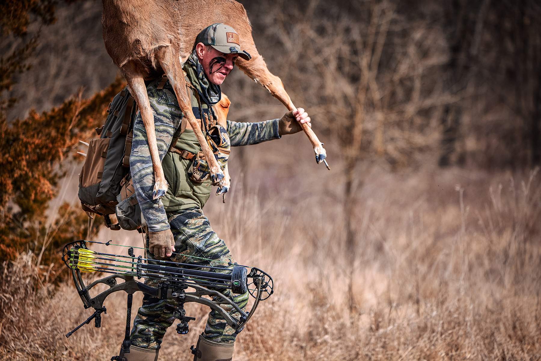 John Dudley carrying a bow and a deer decoy