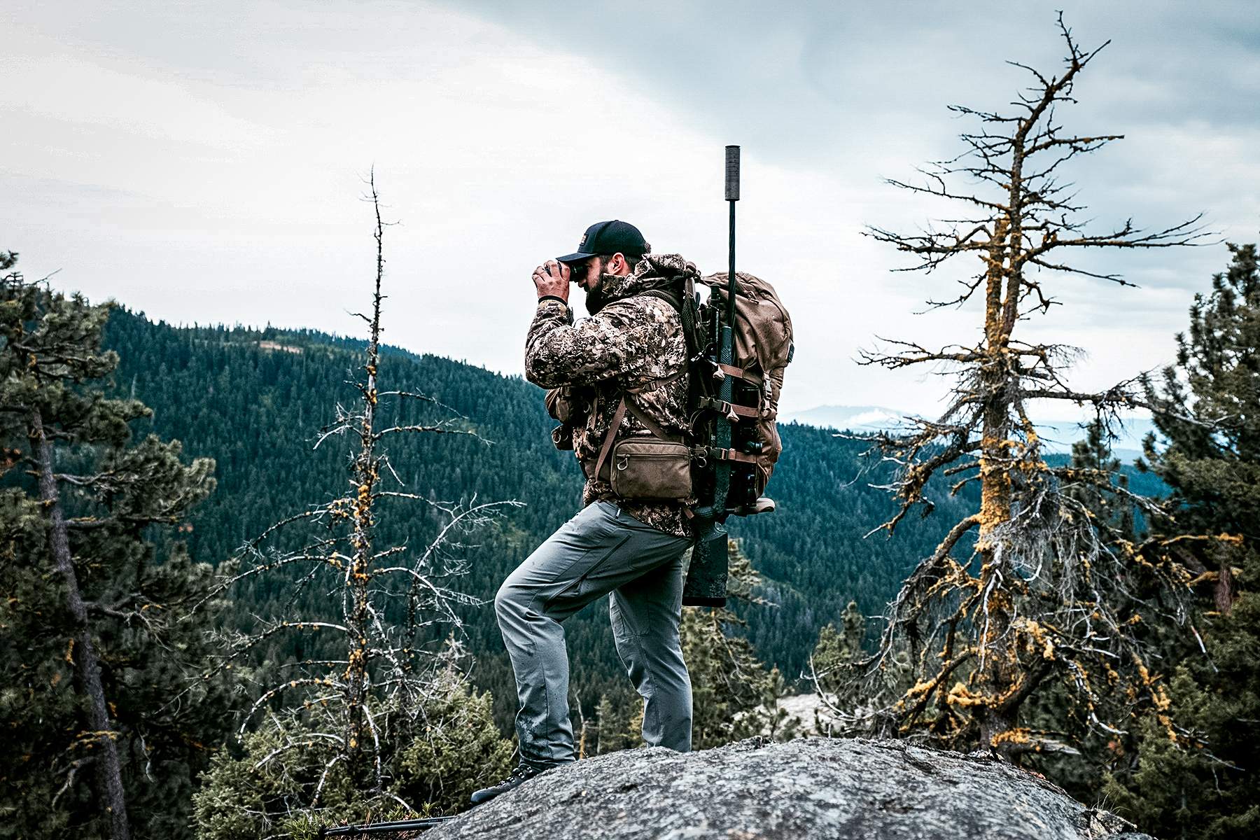 hunter with a suppressed rifle in his pack