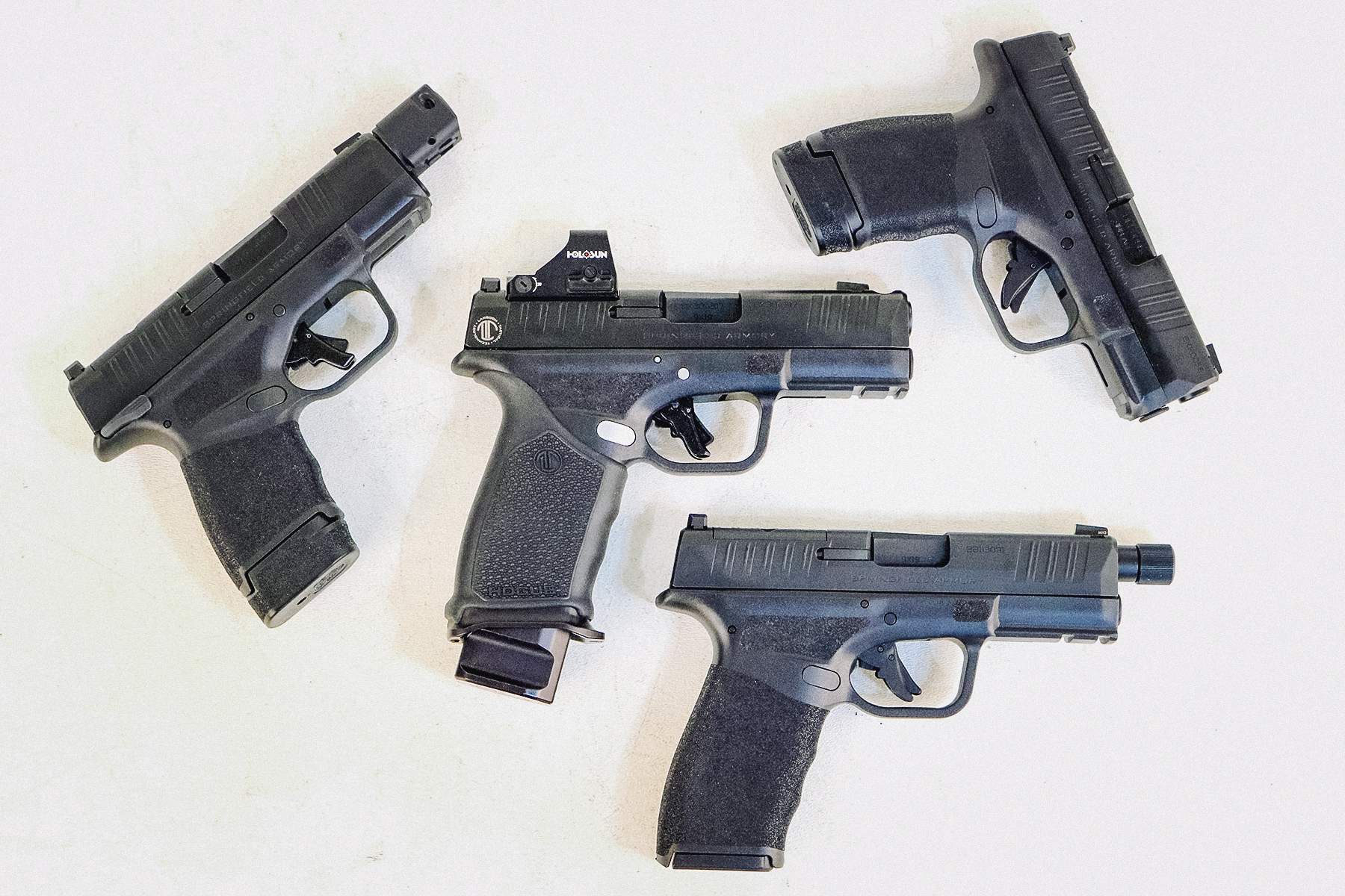 LTT Hellcat Pro with red dot with standard Hellcat, a Hellcat with a compensator, and a Hellcat Pro with a threaded barrel.